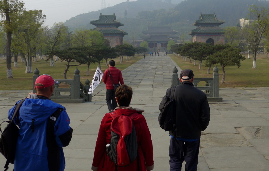 Group of four people walking up towards two Chinese temples