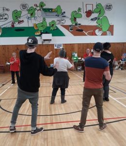 Group of people doing tai chi in a gym