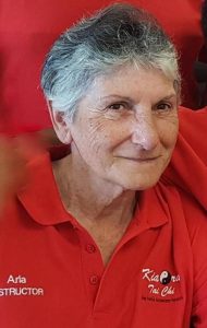 Head and shoulder photo of a smiling woman wearing a red shirt