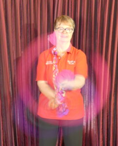 Woman in red shirt whirling two poi
