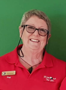 Smiling woman in red shirt and wear a badge that says "instructor"