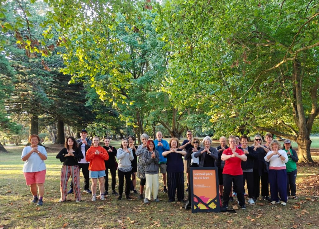 Group of people standing together with their arms and hands in "Wǔshù bàoquán lǐ" (Palm Hold Fist), which is the respect gesture in Chinese martial arts