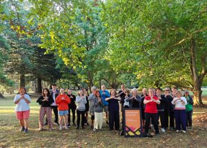 Group of people standing together with their arms and hands in "Wǔshù bàoquán lǐ" (Palm Hold Fist), which is the respect gesture in Chinese martial arts